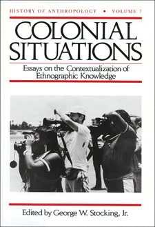 THis book is white with some red and greyscale photograph of a white man and two native americans, all using large cameras, and a black and 