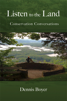 The cover of Listen to the Land is green. With a photo of a person sitting on the wall of a stone circle on a hill overlooking a vast riverine landscape.