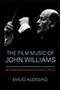 The Film Music of John Williams: a black cover revealing a grayscale photograph of John Williams conducting. The title text is proclaimed in capitalized blue text with a thin line separating it from the red subtitle text. Photograph by Walter H. Scott. Design by Jennifer Conn. 