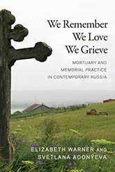 We Remember, We Love, We Grieve: Photo of an aged wooden cross in front of a sprawling, grassy countryside. The land is obscurred by fog in the distance. The sky is gray.