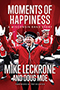 Moments of Happiness: Mike Leckrone, standing in front of the percussion session of the UW Madison marching band, his arms outstretched, a large smile on his face.