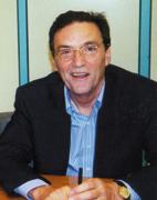 photo of author Bill Christofferson. He is wearing a dark blue blazer and a blue shirt with no tie.