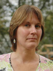 photo of editor Fair shows a woman with short brown hair outside with a background of trees.