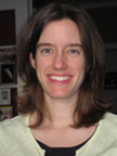 photo of editor Milton shows a woman with long brown hair, in an office, with a green sweater.